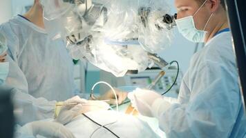 surgeons perform an operation and look through a microscope 3 video