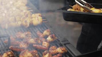 Hand with tongs throws fried chicken in a plate video