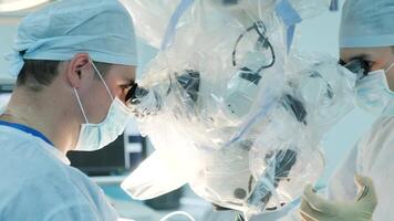 surgeons perform an operation and look through a microscope 2 video