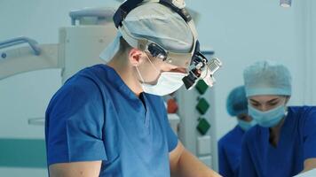 surgeon looks through a mobile microscope and performs an operation video