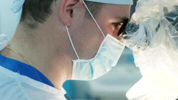 surgeons perform an operation and look through a microscope 4 video