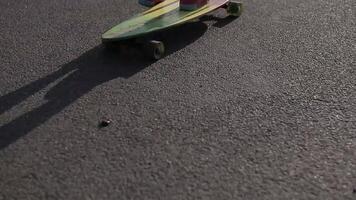 Asphalt shadow of a girl riding with skateboard in the hand on the way. video