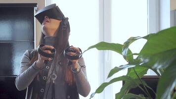 The beautiful girl playing games with virtual reality goggles at the office 3 video