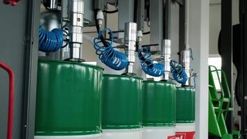 Motor oil in barrels with pump indoors with copy space. Store of lube. Product for bottling close up. Maintenance. Warehouse inside. Background of automotive shop. Auto service. Change of oil. 4 video