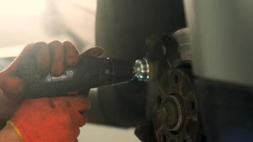 Mechanic is using a brush to clean dust from the drum brake. Selective focus. video