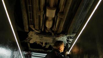 car service, repair, maintenance and people concept - auto mechanic man with lamp working at workshop 4 video
