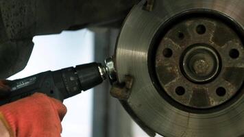 Mechanic is using a brush to clean dust from the drum brake. Selective focus. 3 video