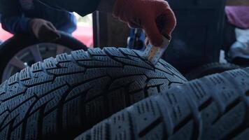 Close-Up Of Man Checking Tread On Car Tyre With Gauge video