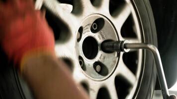 car mechanic screwing or unscrewing car wheel of lifted automobile at repair service station 2 video