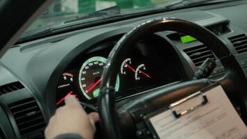 Hand of mechanic taking notes under in the car and checks lights video
