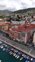 Aerial view of Nice, French Riviera, with colorful boats in the vibrant port, charming Mediterranean architecture, red-tiled roofs, and lush green hills. video