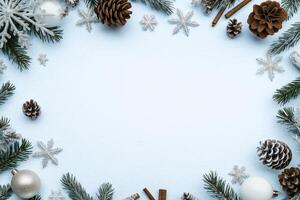 Flat lay winter holiday background with pinecones snowflakes fir branches cinnamon sticks and ornaments on light blue textured surface photo
