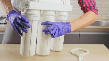 plumber works with a replaceable water filter. Filtration by reverse osmosis. Replacement of the landing filter in the water purification system. video