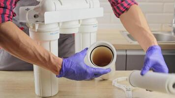 plumber works with a replaceable water filter. Water filtration by reverse osmosis. Replacement of the landing filter in the water purification system. video