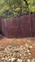 Tree fence in desert terrain, sand and stone path video