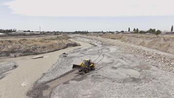 Front loader adjusts the riverbed of a mountain creek in Sokuluk, Kyrgyzstan - July 3, 2024 video