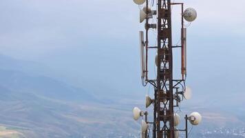 telecommunication tower in front of overcast sky and mountains on horizon 3 video