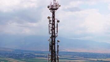 telecommunication tower in front of overcast sky and mountains on horizon 4 video