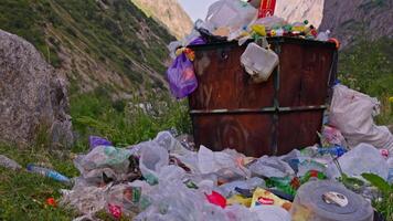 Overfilled garbage bin with trash around in mountains of Kyrgyzstan video