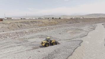 A front loader adjusts the riverbed of a mountain creek in Sokuluk, Kyrgyzstan - July 3, 2024. video