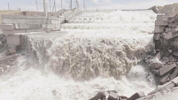Splashing White Water Cascading Over a Waterfall Edge of concrete water spillway at sunny day video