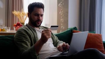 irritado Bravo caucasiano homem masculino cara cliente proprietário cliente homem de negocios segurando crédito cartão digitando computador portátil computador pagar conectados falhou Acesso negado entrando senha erro erro fracasso golpe às casa video
