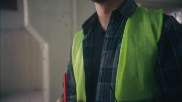 Thoughtful pensive Caucasian man builder industry engineer manufacture worker thinking writing construction plan foreman inspecting male in hard hat architect guy correct paper build project analysing video