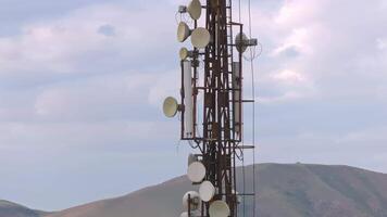 telecommunication tower in front of overcast sky and mountains on horizon in Kyrgyzstan video