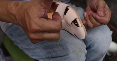 Making handmade shoe products in craft workshop. Hands of artisan shoemaker video