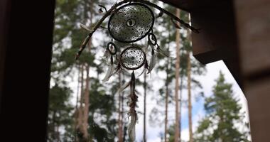 Dream catcher dancing in the wind in a forest. Indian amulet dreamcatcher swaying in the wind video