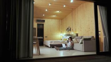 Comfortable accommodation features wooden walls and modern amenities, creating a relaxing atmosphere for remote work during a peaceful evening video