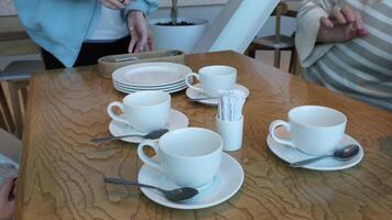 Tea Setup Featuring White Cups Beautifully Arranged on a Wooden Table Surface video