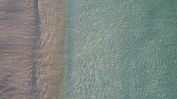 aerial top down view footage by drone of clean seawater in the shore of a beach, background summer concept texture video