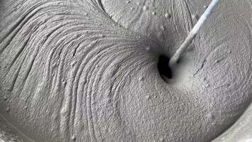 liquid cement or concrete mixture being poured into a vortex, creating a swirling pattern. Ideal for construction, industrial, and texture backgrounds video