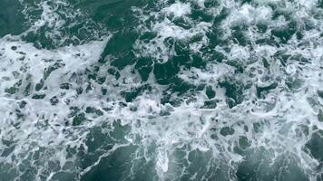 Aerial view of ocean waves forming white foam as a ship moves through the sea. Perfect for backgrounds, marine themes, and travel concepts video