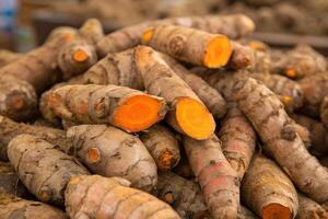 Pile of Fresh Turmeric Roots with Sliced Sections photo