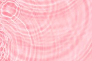 Water background for cosmetic,spa product banner,Pink ripples water surface. with splashes and bubbles. Defocus water waves with light shining on abstract circle pattern background for spring,summer photo