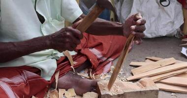 A man is working with wood tools, using the natural material video