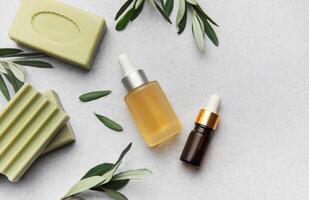Soap, essential oil and olive branches creating relaxing atmosphere photo