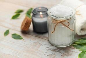 Magnesium flakes in a jar with burning candle for a relaxing spa treatment photo