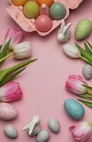 Easter eggs, ceramic bunnies and tulips creating a frame on pink background photo