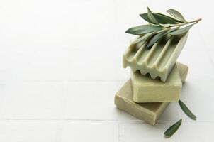Olive soap bars forming a stack with olive branch on top photo
