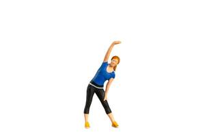 A figurine of a woman in workout attire performing a side stretch isolated on white background with clipping path photo