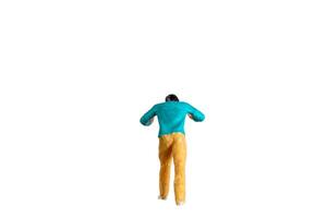 Miniature Figurine Pushing Against Invisible Force isolated on white with clipping path photo