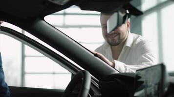 Happy caucasian woman is sitting in the drivers seat of a new grey car sedan. Concept a premium car-buying experience that combines expert guidance with high-end service in an elegant setting. video