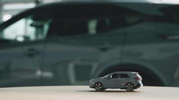 A small car model toy is placed on a table against blurred auto background. Premium car buying experience that combines expert guidance with high-class service video