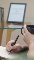 A thoughtful person reflects while enjoying the aroma of freshly brewed coffee, jotting down creative ideas in a notebook on a desk. This serene atmosphere enhances creativity and focus video