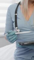 A healthcare professional in blue attire and gloves is using a tablet during a doctors appointment, highlighting modern medical practices and the integration of technology in todays healthcare video