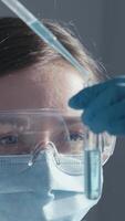 In a busy hightech lab, a dedicated scientist in protective gear examines a test tube of vibrant blue liquid, representing the rigorous nature and advancements in science and medicine video