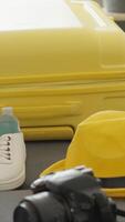 A bright yellow suitcase is prominently placed with travel essentials like a camera, comfy sneakers, and a stylish hat, embodying the excitement of gearing up for an adventurous trip video